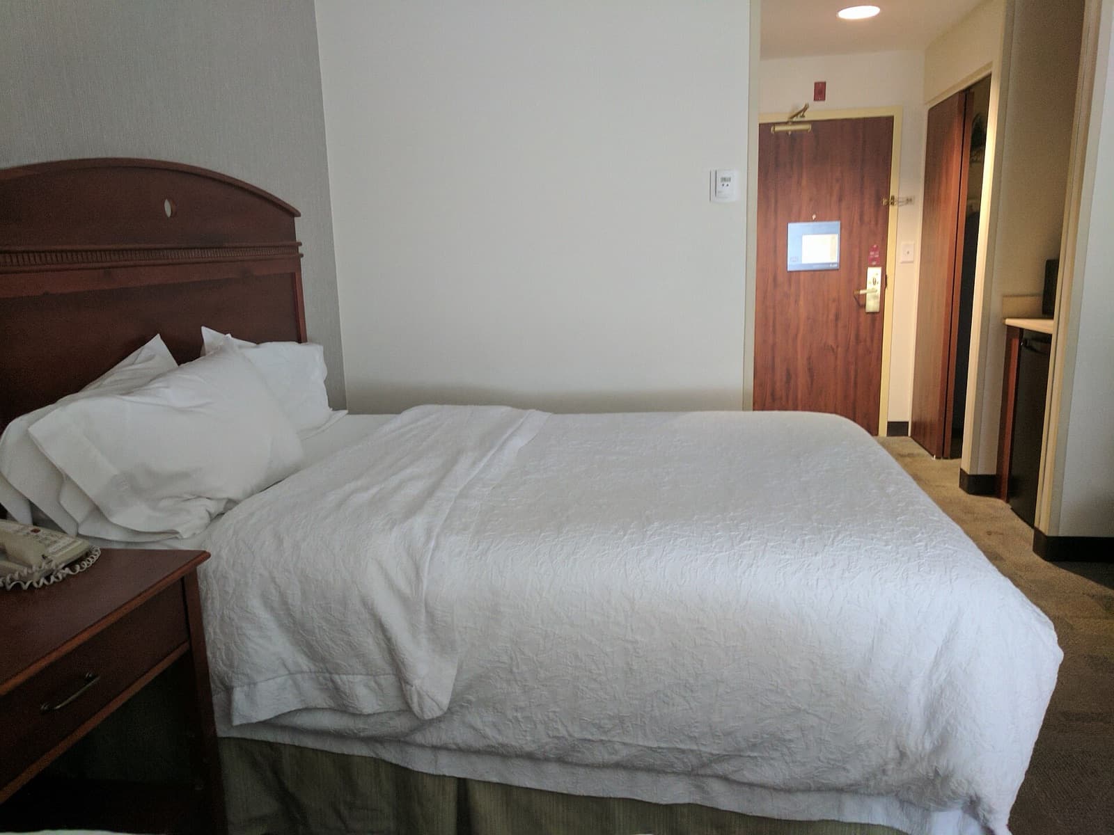 A furnished bedroom with a made bed and natural light.