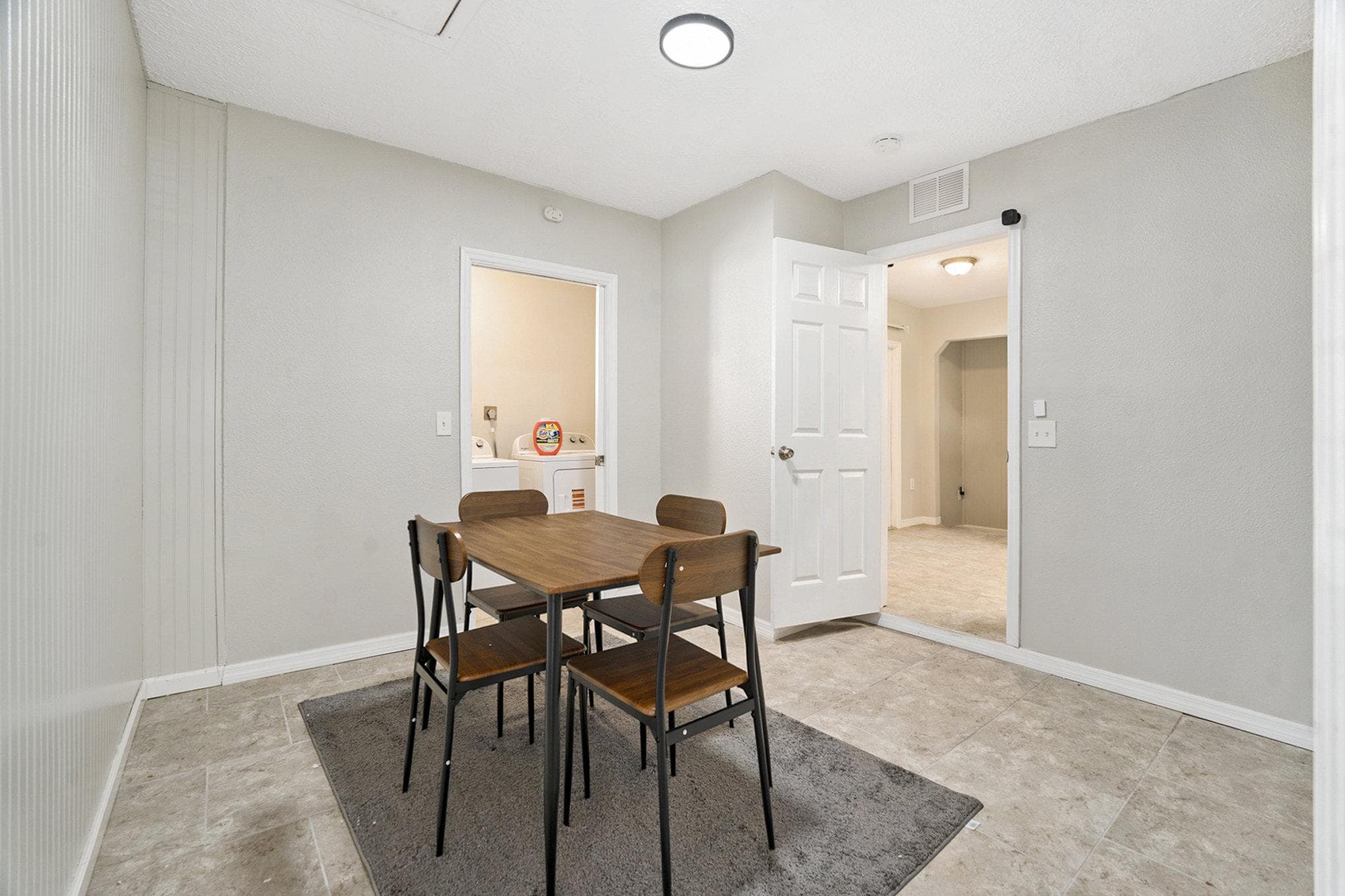 This inviting dining room offers a cozy space for shared meals and connection with housemates. The modern table and stylish chairs create a welcoming atmosphere for gatherings, enhancing the communal living experience.