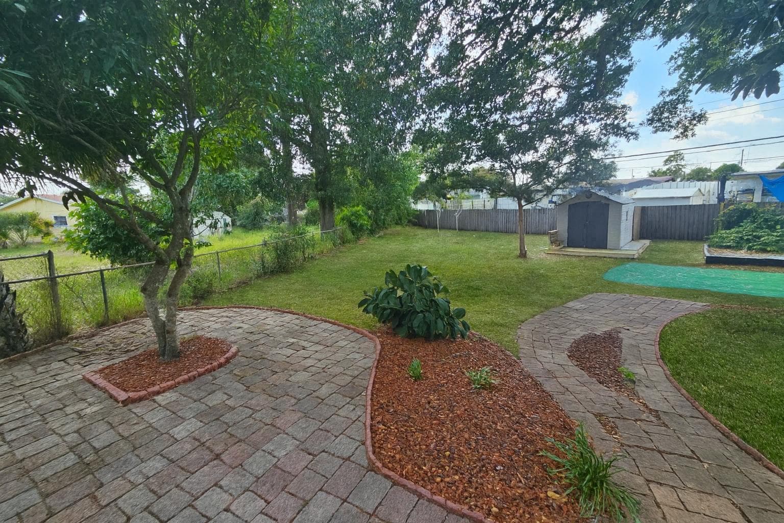 Welcome to your serene outdoor escape! This beautifully landscaped garden features a charming stone pathway winding through lush greenery, perfect for morning coffee or relaxing in the sun. The spacious yard provides a peaceful retreat, ideal for gatherings or personal relaxation.