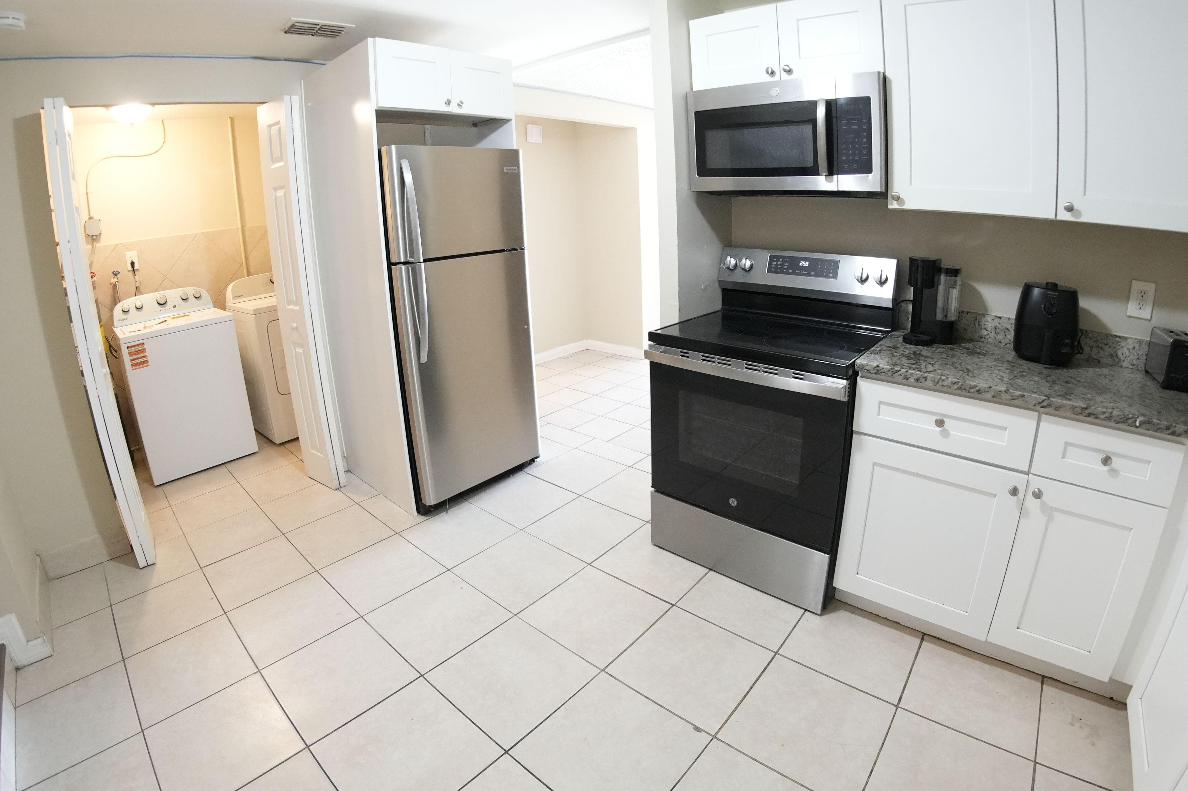 Welcome to your future kitchen! This spacious area features modern appliances, including a sleek stainless steel fridge and oven, ensuring you have everything you need for culinary adventures. The tiled floor adds a touch of elegance, while the layout promotes an inviting atmosphere, perfect for communal cooking or quick meals. Don't miss the handy laundry area just steps away, making chores a breeze!