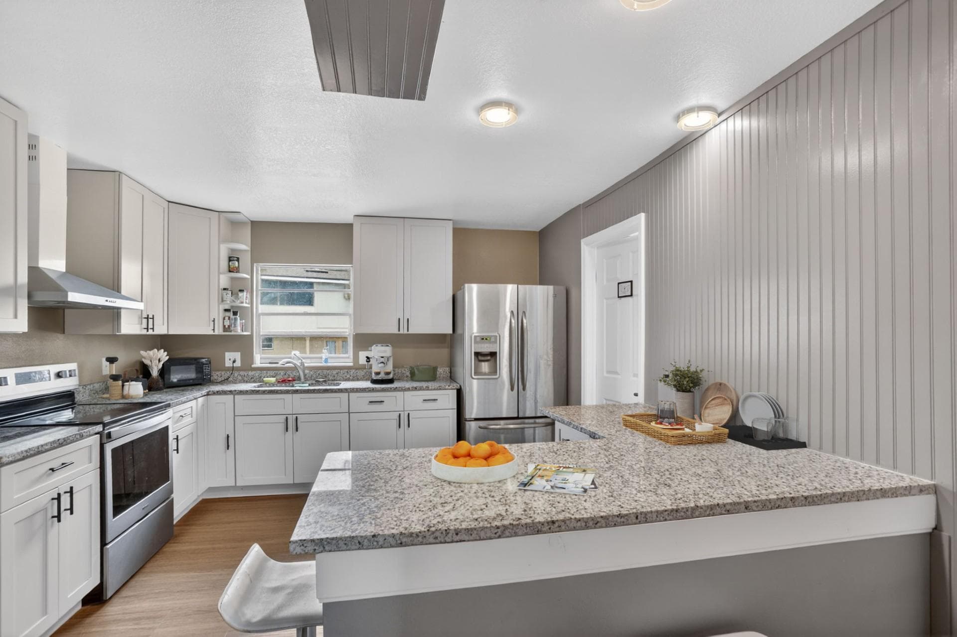 Updated kitchen with ample cabinetry, granite-look counters, and stainless appliances including a French-door fridge.