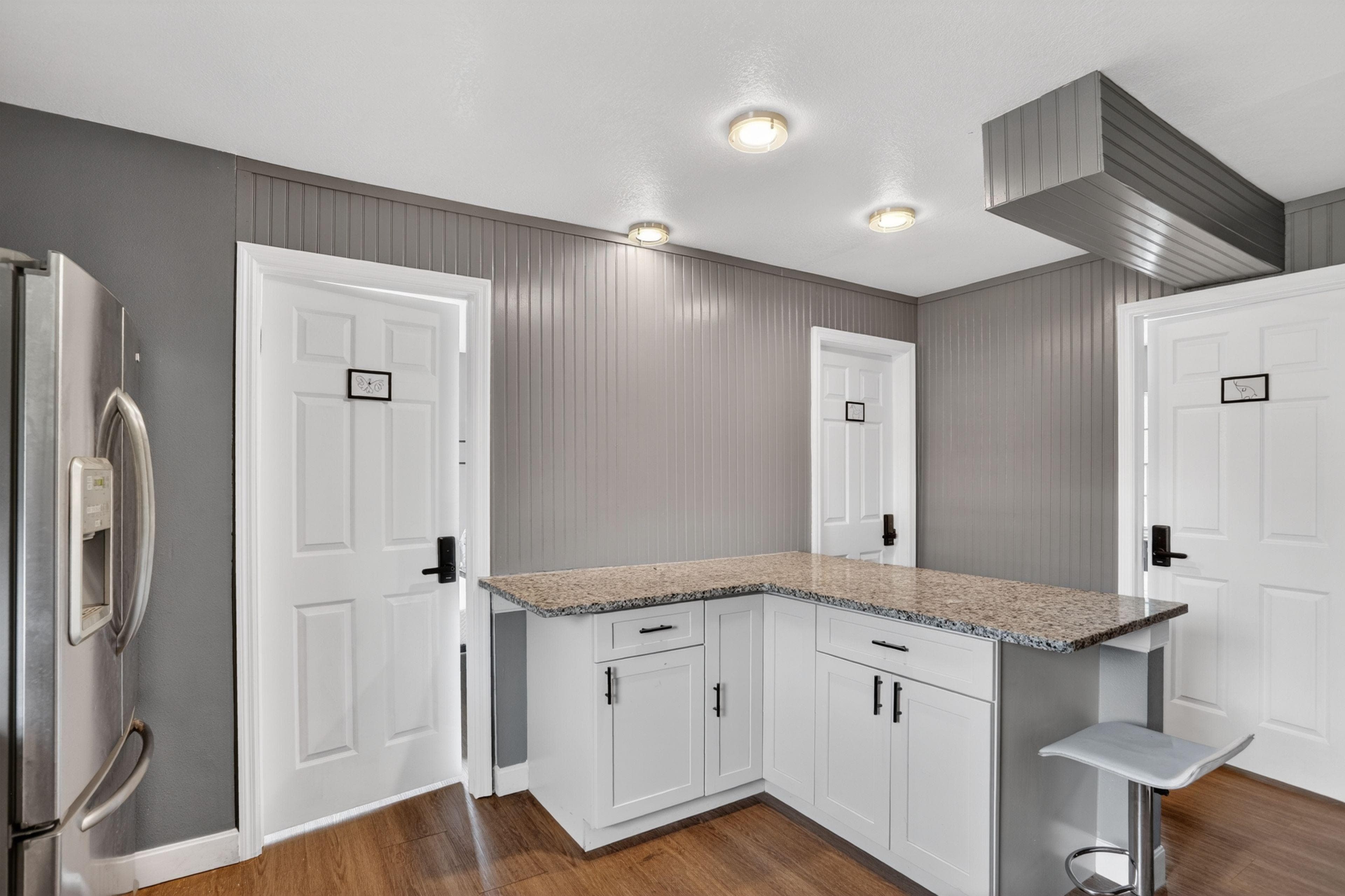 Updated kitchen with granite-look counters, ample cabinetry, and stainless refrigerator, plus a handy breakfast bar.