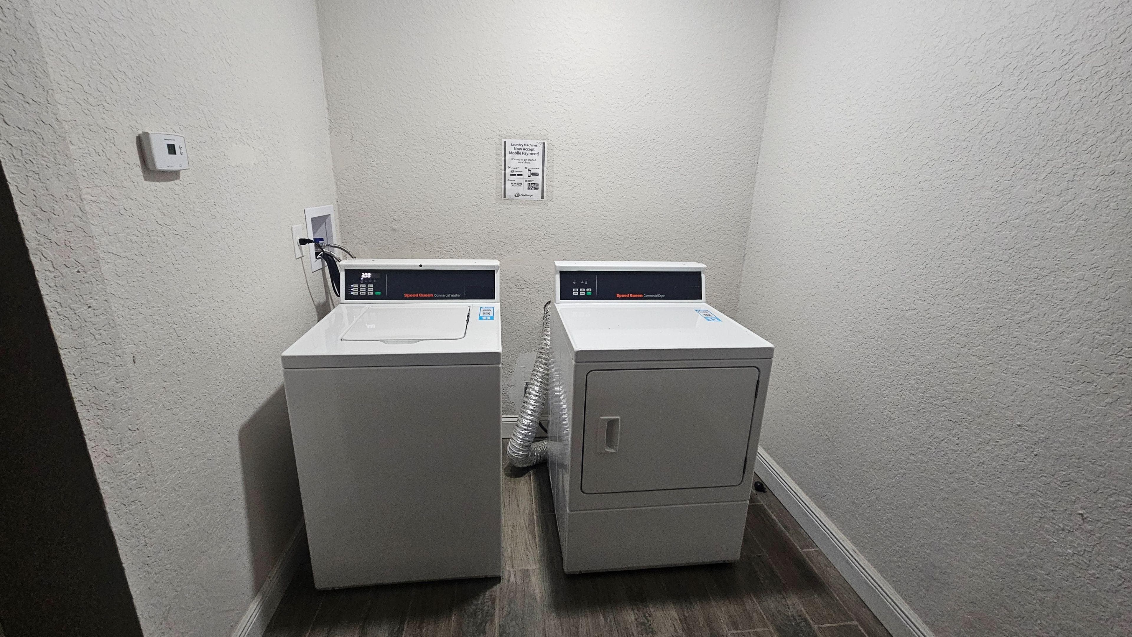 Dedicated laundry nook with commercial-grade washer and dryer, offering convenient on-site laundry for residents.
