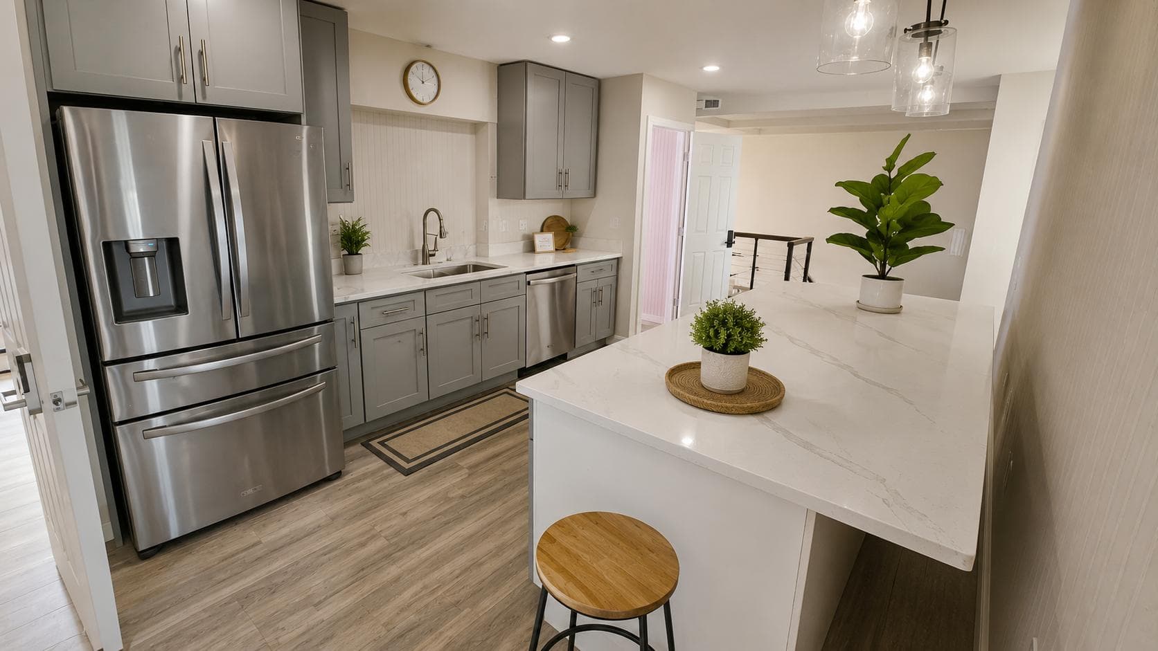 Updated kitchen with stainless steel appliances, ample cabinetry, and a large quartz island for prep and seating.